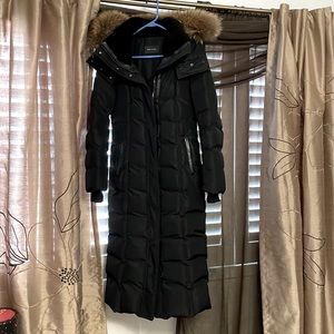 Mackage coat. It has leather trim on belt and pockets and a faux fur on hoodie.